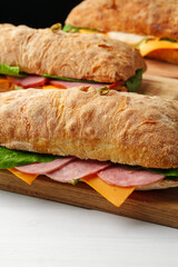 Chiabatta sandwich with ham and cheese on wooden board