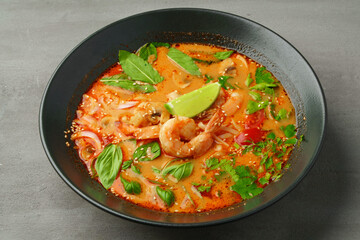 Tom Yum spicy Thai soup on gray background
