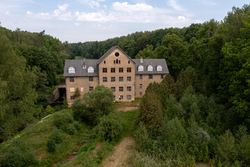 Fototapeta na wymiar The ancient Katrina mill building in a picturesque location by the lake, Krimulda, Latvia