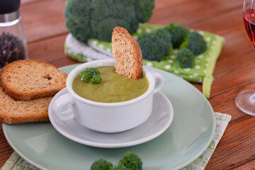 Broccoli. A green cream soup of broccoli with croutons for a healthy eating without calories but with vitamins. Concept of healthy nutrition. Wooden background