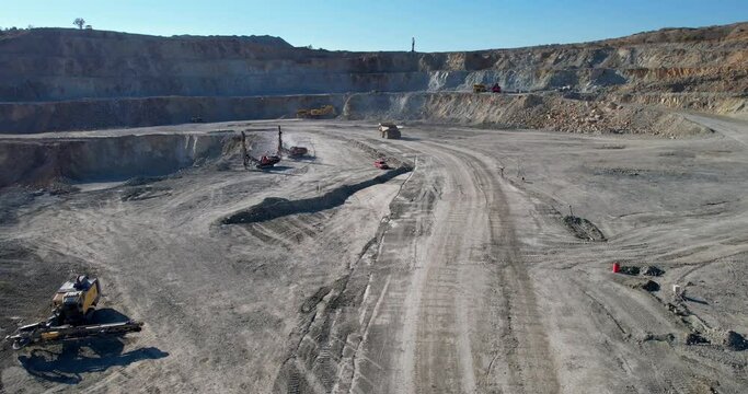 View of at opencast mining pit with lots of machinery escavators and trucks