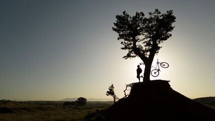 Awakening in Triumph: A Cyclist's Joyful Celebration at Nature's Sunrise Spectacle