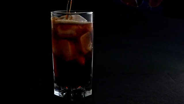 Making Cuba libre cocktail on black background