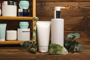 Tubes with cream on the background of a brown tabletop in the bathroom. Shelf with cosmetics. Face and body skin care. Moisturizer, toner and serum. Beauty concept. Place for text. Copy space.