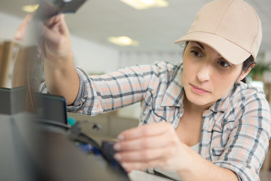 Mature Woman Fixing A Printer