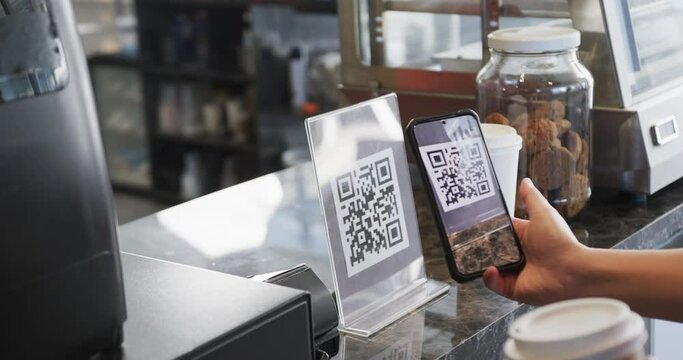 Caucasian customer scanning qr code with smartphone in bakery in slow motion