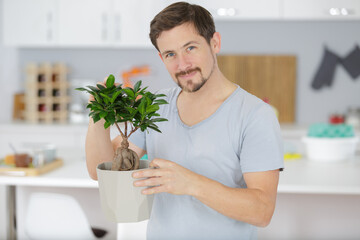 man taking care of bonsai plant