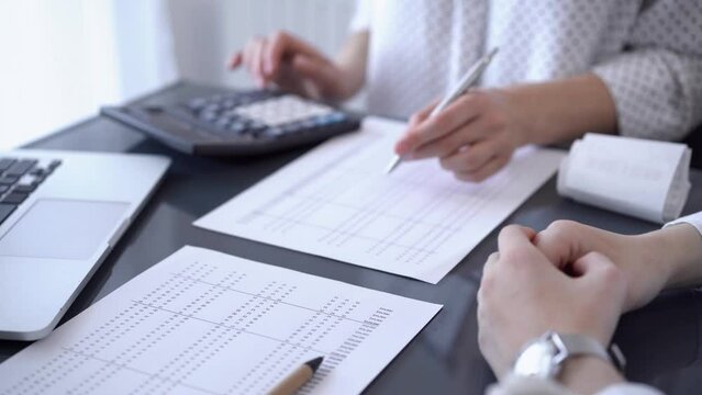 Female accountant counting taxes or making revenue balance for a client. Business audit and finance concepts