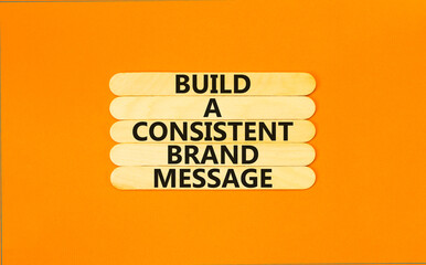Consistent brand message symbol. Concept words build a consistent brand message on wooden stick. Beautiful orange table orange background. Business consistent brand message concept. Copy space.