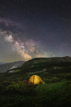 Atmospheric photo of a tourist tent in the mountains under the stars and the milky way