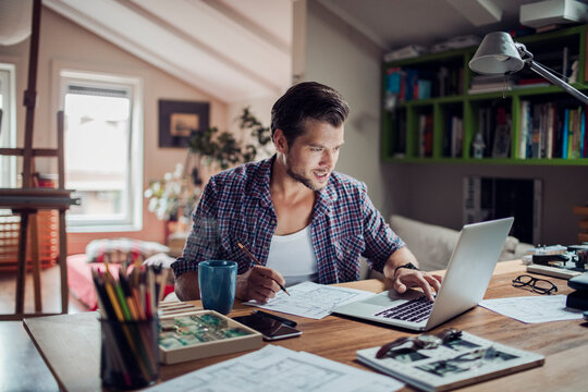 Young man working from home on his laptop