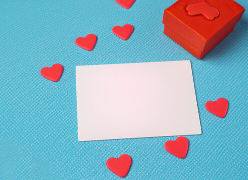 Empty White Gift Card for Congratulation, Love Hearts Stickers, Red Gift Box, Blue Table, a template for designer, using Generative Ai technologie