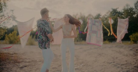 Young couple dancing bachata against sarongs at beach - Powered by Adobe