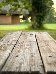 Fototapeta premium Closeup of a wooden picnic table in the park at sunset