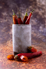 Dried chilies in a jar over dark background
