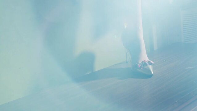 Bejeweled high heeled shoe standing on a wooden surface 