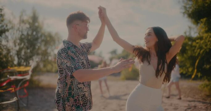 Smiling young female brunette dancing bachata with boyfriend