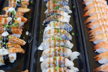 Salmon and shrimp sushi arranged in a row.