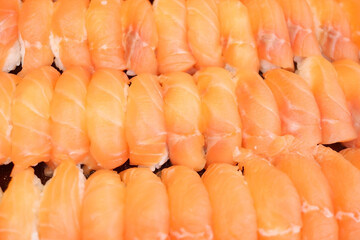 Salmon and shrimp sushi arranged in a row.