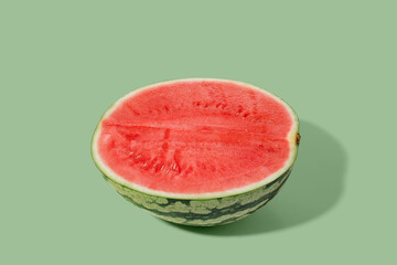 Cut watermelon on green pastel background