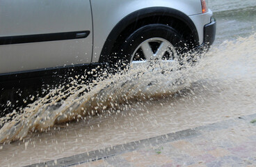 Car wheels in water during rain