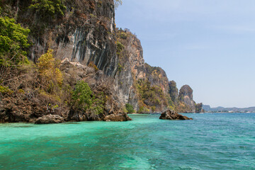 Fototapeta premium Cliff shoreline with tourquise water near Ko Phi Phi island in Thailand
