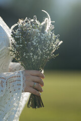 Gypsophila wedding bouquet in bride's hand in back light. Space for text.