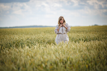Fototapeta na wymiar beautiful girl in a linen dress in a wheat field