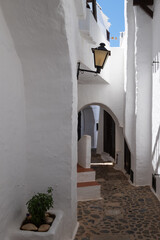 Narrow street with white houses in the picturesque village of Binibequer on the Spanish island of Minorca.