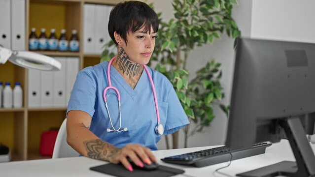 Hispanic woman with amputee arm doctor using computer working at clinic