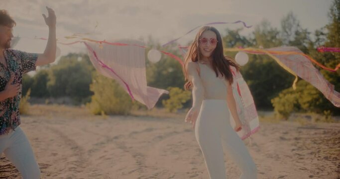 Young couple dancing bachata against sarongs hanging at beach