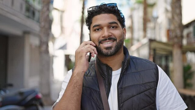 African american man smiling confident talking on smartphone at street