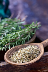 Fresh and chopped rosemary in a wooden spoon, close-up