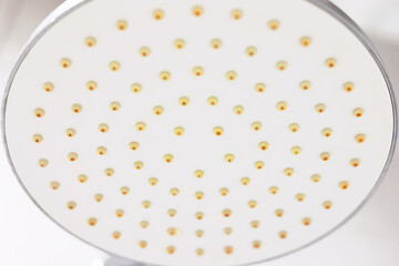 Dirty calcified circle shower head and arm, chrome mixer tap, faucet with rust and limescale, plaque from hard water, close up, Bottom view. Cleaning company concept.
