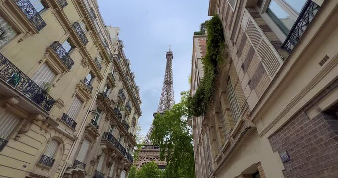 The most popular street and photo spot with the Eiffel Tower in the background. Romantic cozy view of the famous Eiffel tower from a small Paris street in summer. Wide horizontal panorama