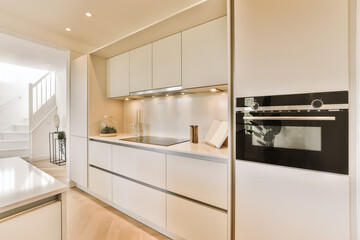 a modern kitchen with white cabinets and wood flooring in the center of the room is an open...