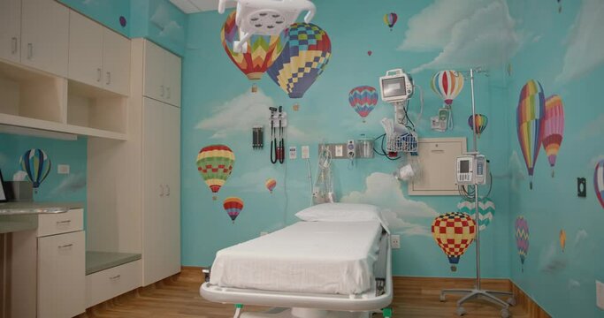 Empty children's hospital room with bed colorful wallpaper