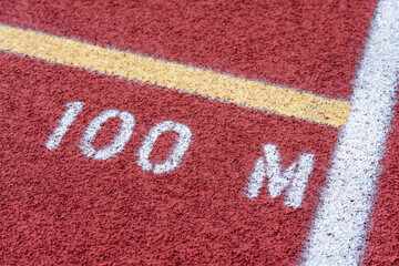 Close up of new red running track with 100 M text	