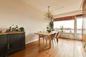 a dining room with wood flooring and an open window looking out onto the cityscapearl view