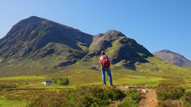 Standing woman enjoying epic view of picturesque Glen Etive mountain in the Scottish Highlands, West Highland Way, Scotland