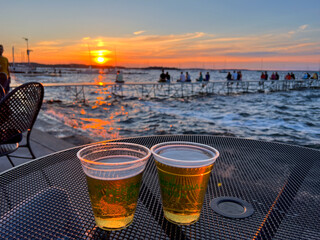 MADISON, WISCONSIN, JULY 16 2022: Drinking two beers during summer sunset at Madison Memorial Union - obrazy, fototapety, plakaty