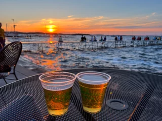 Poster de jardin Coucher de soleil sur la plage MADISON, WISCONSIN, JULY 16 2022: Drinking two beers during summer sunset at Madison Memorial Union