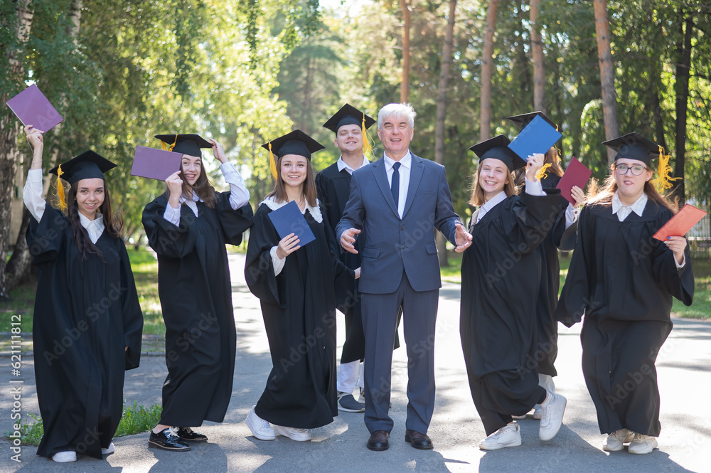 Wall mural A university professor and seven robed graduates are jumping outdoors.