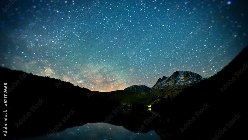 Wall mural amazing time-lapse of the night sky with the stars being reflected in a lake.