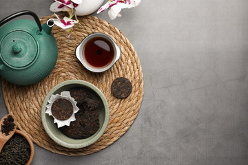Flat lay composition with aromatic pu-erh tea on grey table. Space for text