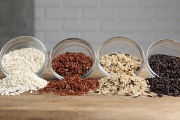 Different types of rice on wooden table, closeup