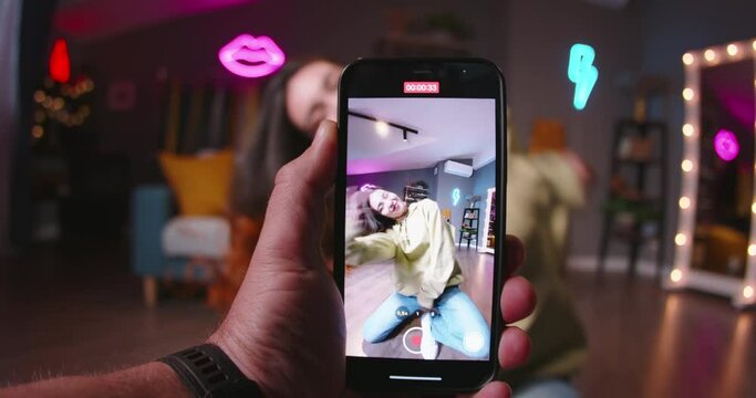 Asian girl recording video of trending hip hop dance challenge for likes and followers on social media platform. Dancing while shooting video content for social networks on smartphone camera