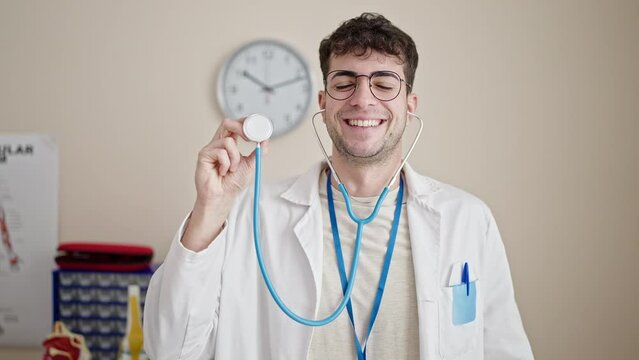 Young hispanic man doctor smiling confident holding stethoscope at clinic