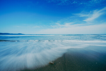 砂浜の上を流れる海の波