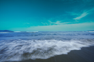 Fototapeta na wymiar 砂浜の上を流れる海の波